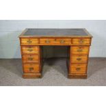 A small Edwardian oak writing desk, darkly 20th century, with a leathered top over three frieze