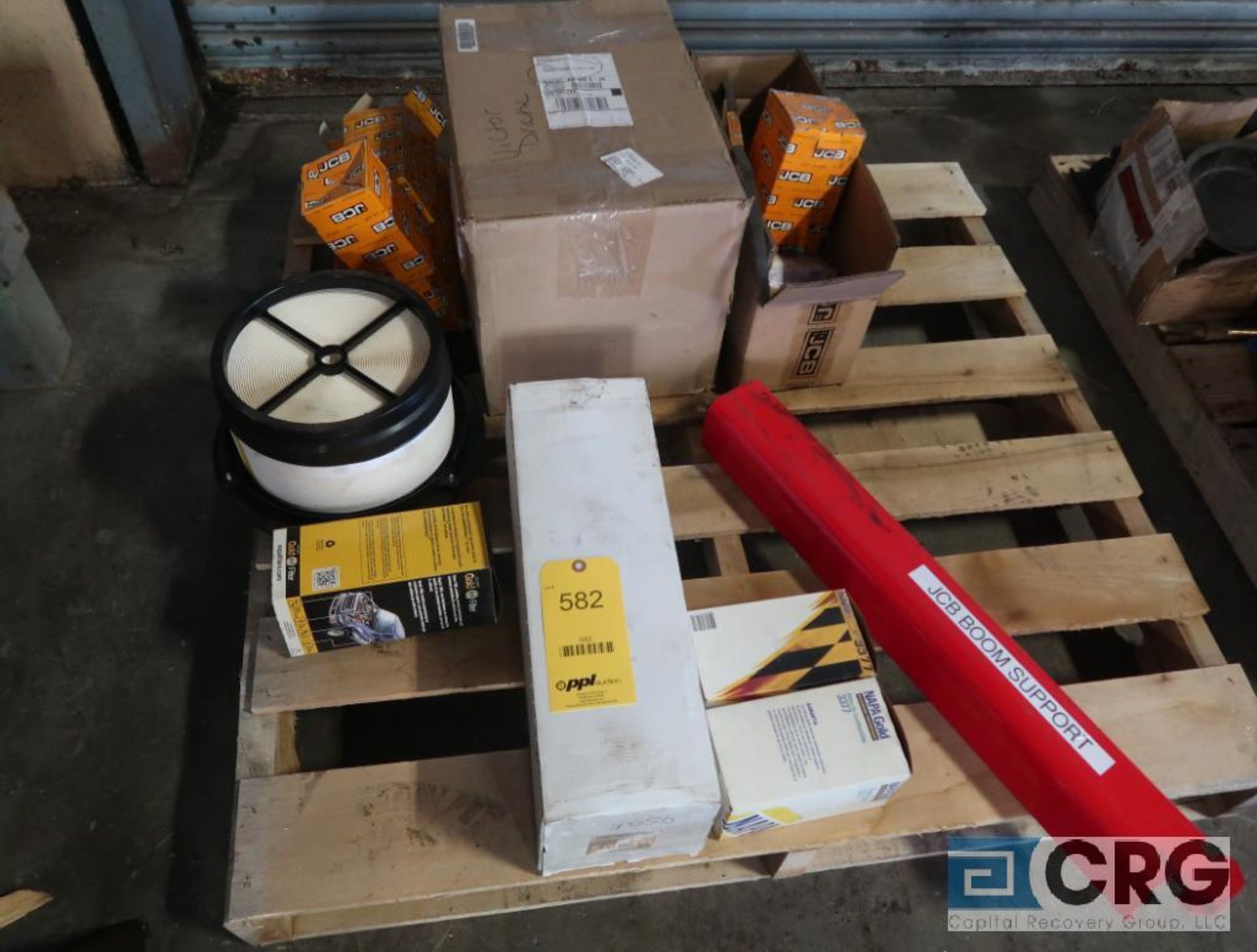 Lot of assorted JCB parts including belts, filters, and boom support (Maintenance Shop)
