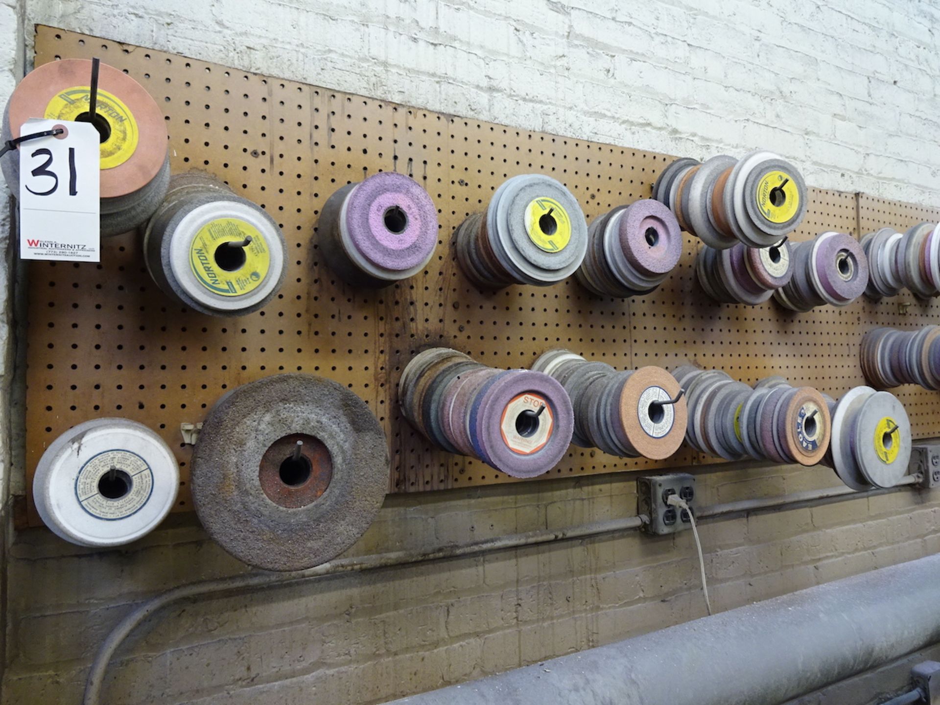 LOT: ASSORTED GRINDING WHEELS ON WALL