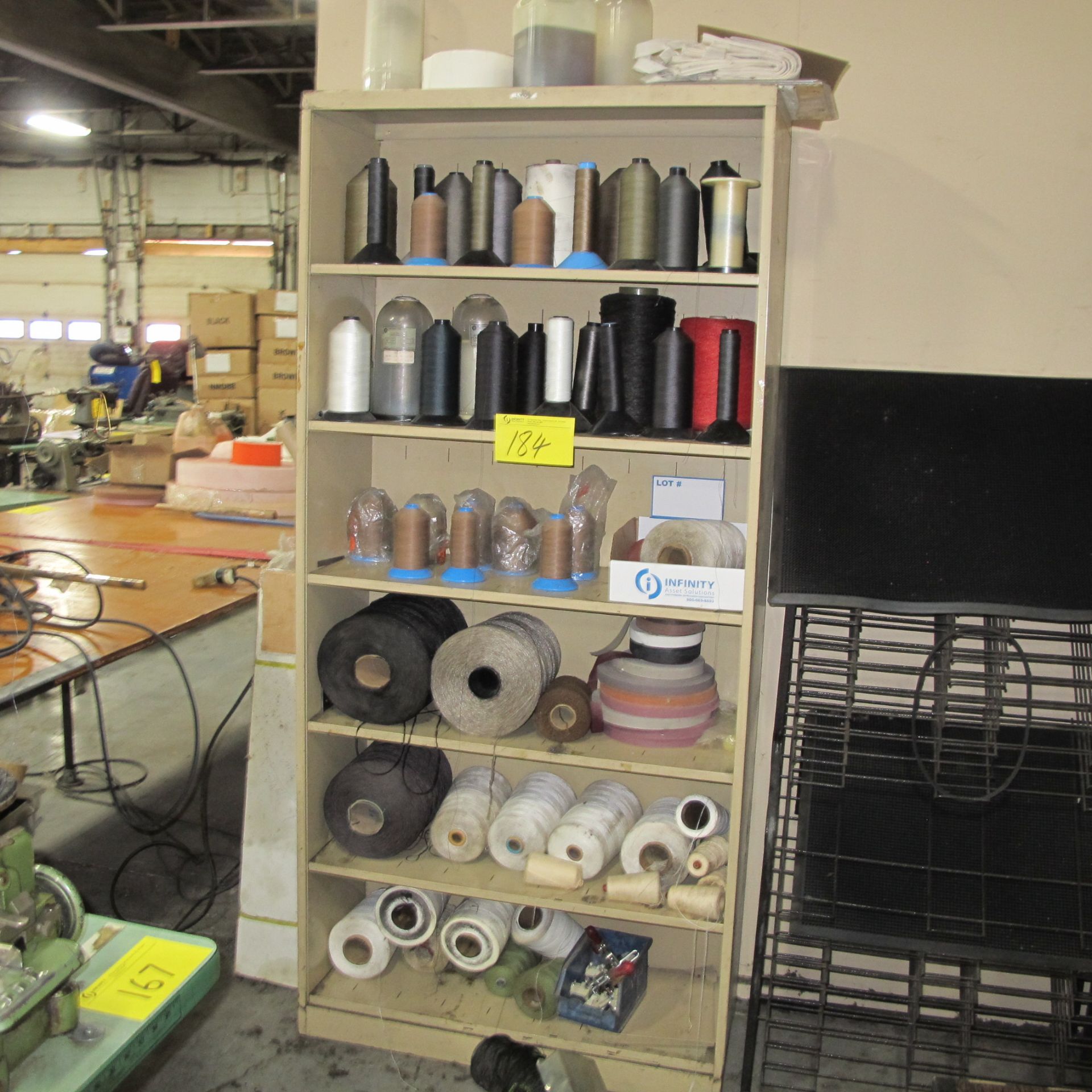 LOT OF (2) SHELVING UNITS W/ SPOOLS OF THREAD, (3) BOXES OF BELTS AND VARIOUS SEWING MACHINE PARTS