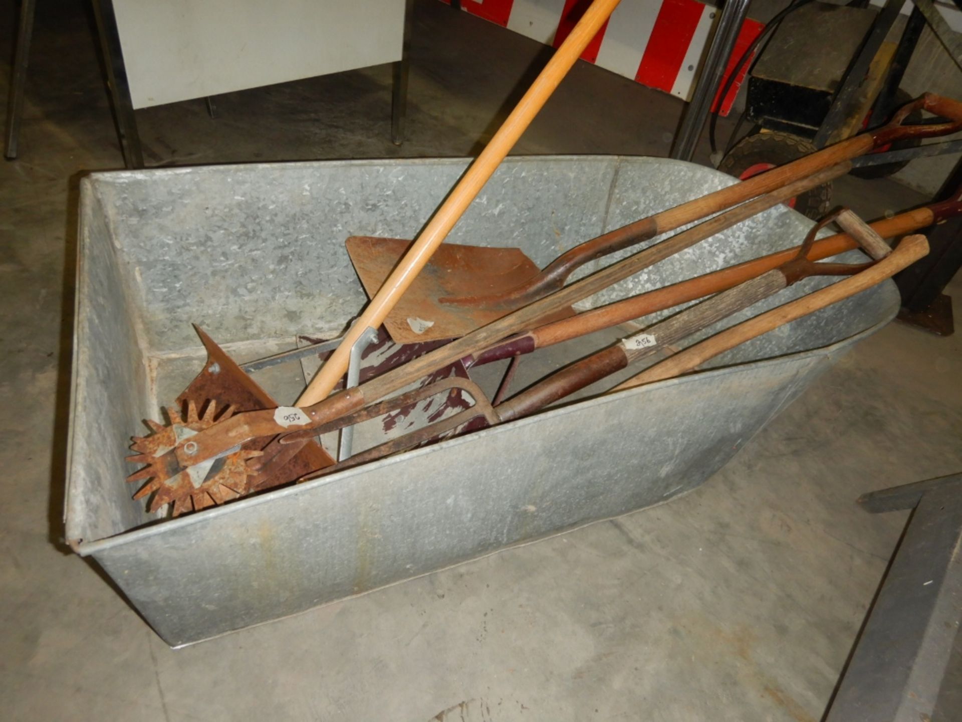 ANTIQUE METAL BATH TUB W/ASSORTED ANTIQUE YARD TOOLS