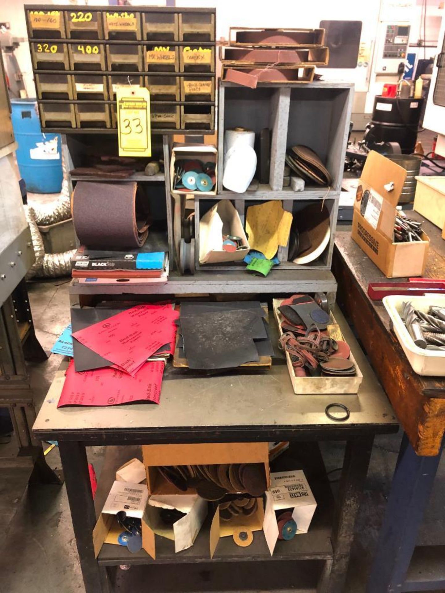 SHELF W/ ASSORTED SANDPAPER, DISC, AND WHEELS