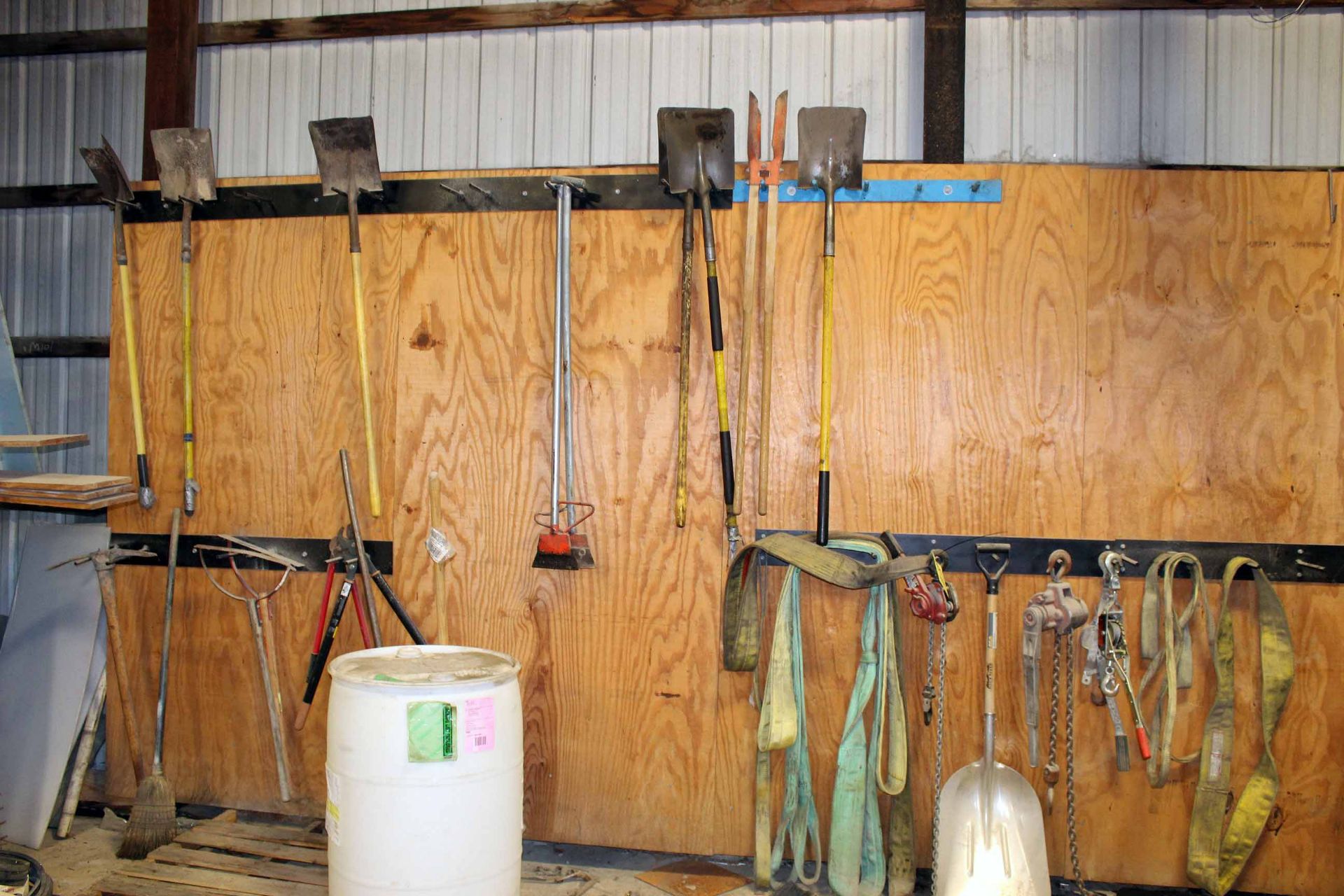 LOT CONTENTS OF WALL: brooms, shovels, etc.