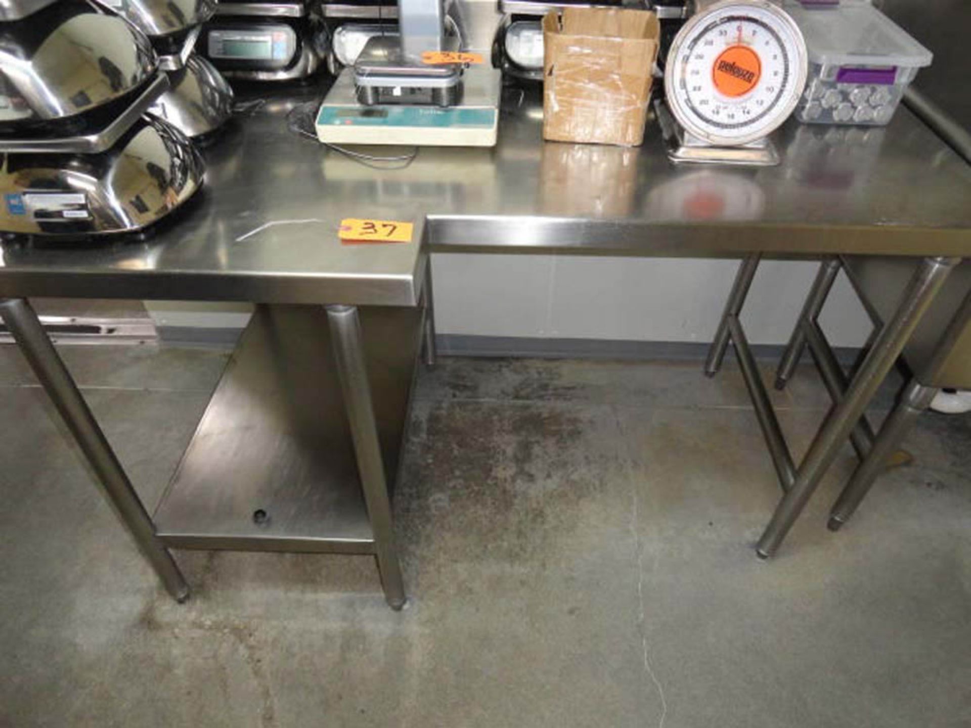 STAINLESS STEEL TABLE, "L" SHAPED, 60" X 30/38" WITH BACK SPLASH