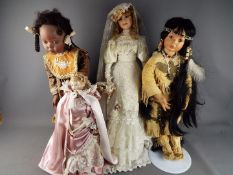 A collection of four unboxed vintage collectors dolls.