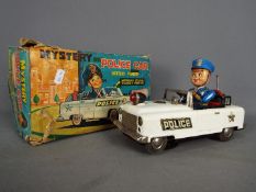 Nomura (TN Toys of Japan) - A boxed battery operated tinplate Mystery Police Car by Nomura (TN