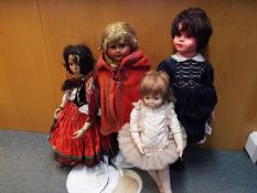 A collection of four unboxed collectors dolls.