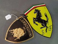 Two cast iron wall plaques, one marked Ferrari the other Lamborghini.