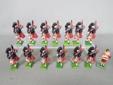 Britains - A small unit of unboxed Britains marching Highlander Pipers soldiers and a Poppy Seller.