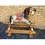 A good quality early 20th century rocking horse on glider base, painted dapple body with open mouth,