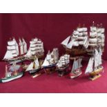 A flotilla of ten static wooden models on stands depicting fishing vessels,