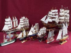 A flotilla of ten static wooden models on stands depicting fishing vessels,