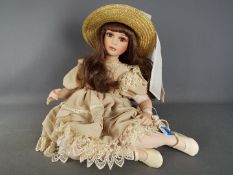 Alberon - A limited edition porcelain dressed doll by Alberon in the form of a young girl seated,