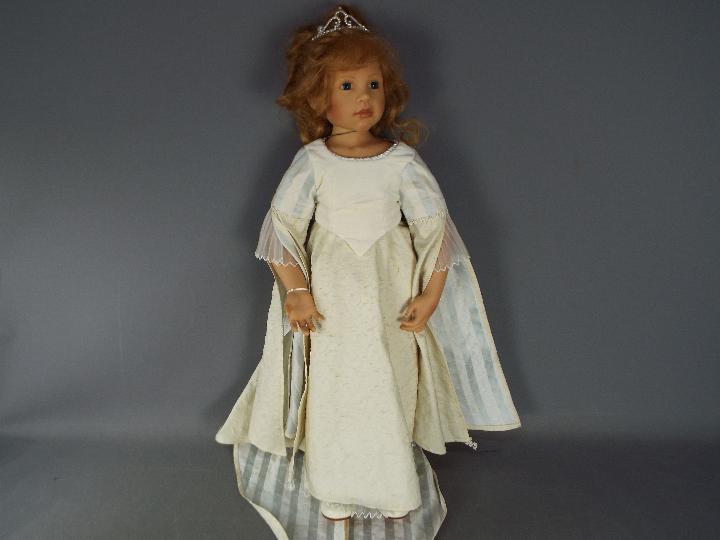 A good quality vinyl dressed doll modelled as a young girl, wearing tiara and necklace,
