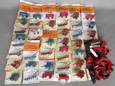 Ertl - Over 40 predominately carded 1:64 diecast farm implements from Ertl.