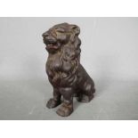 A cast iron money bank in the form of a seated male lion,