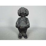 A cast iron, novelty money bank in the form of a standing Golly,