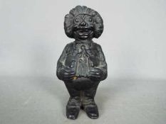 A cast iron, novelty money bank in the form of a standing Golly,