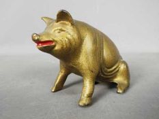 A vintage, cast iron, novelty money bank in the form of a seated pig by A.C.