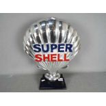 A chrome Super Shell sign on wooden base,