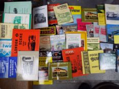 A large collection of hardback and paperback books relating to buses and tramcars contained in 2