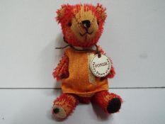 Witney - Teddy Bear - "Fonzie". Jointed. Bag and paper necklace. 9cm.