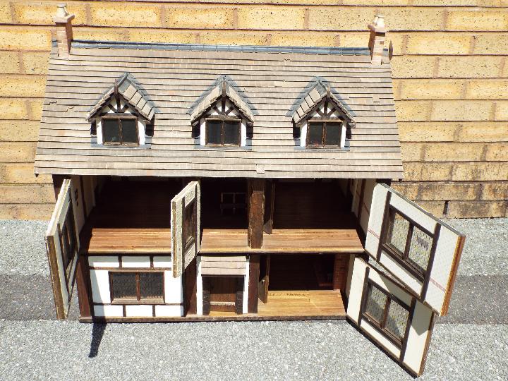 An illuminated hand built wooden three storey Tudor style dolls house, - Image 4 of 4