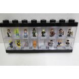 LEGO - A black plastic Lego display case in black containing 15 Lego minifigures.