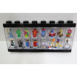 LEGO - A black plastic Lego display case in black containing 16 Lego minifigures.