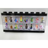 LEGO - A black plastic Lego display case in black containing 16 Lego minifigures.