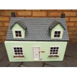 A scratch built wooden yellow two storey dolls house.