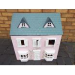 A scratch built wooden pink two storey dolls house.