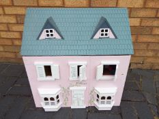 A scratch built wooden pink two storey dolls house.