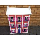 A scratch built wooden three storey dolls house.