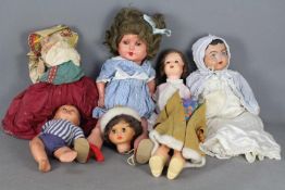 An assortment of unmarked dolls made from a variety of materials.
