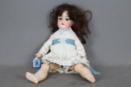 Armand Marseille - A vintage Armand Marseille bisque headed doll on jointed composition body of a
