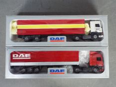 Tekno - 2 x boxed DAF trucks in 1:50 scale. The red and yellow trailer has a broken rear door hinge.