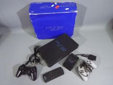 Sony Play Station 2 - A boxed Play Station 2 including 2 x controllers, a remote and a power cord.