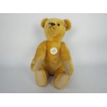 Steiff - one Steiff teddy bear - a "1908 replica" teddy bear with a white tag on its ear.