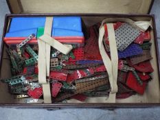 Meccano - A vintage suitcase full of a large quantity of Meccano parts including wheels and cogs,