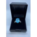 Stone Set Silver Ring Having a Large Oval Sparkling Topaz Coloured Stone in Claw Mount. Design