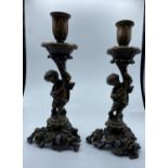 A Pair of Antique Bronze Candlesticks with Cherubs, weight 2.9kg and 26cm tall (2)