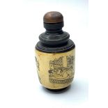 A Chinese bone and ebonised wood snuff bottle with three erotic engravings