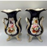 A pair of Daniel four footed vases with floral cartouche, 19cms tall