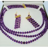 A three row amethyst necklace and matching earrings set in a presentation box. Necklace length: 47 -