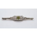 An antique art deco platinum bar brooch with diamonds and central periodt, weight 4.8g and length