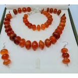 A highly polished carnelian and silver (stamped "925") necklace, bracelet and earrings set in a