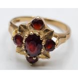 9ct Gold Ring with Five Garnets in a Flower Head Formation. Size O/P, 3.6 grams approx.