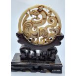 A Chinese carved white ("Hotan") jade disc (amulet?) with mythical beasts on a custom made wooden