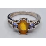 Stone Set Silver Ring Having a Pale Orange Stone with a Sapphire Coloured Stone to Each Side of